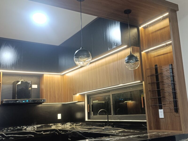 Cocina negra con piedra tecnológica y madera