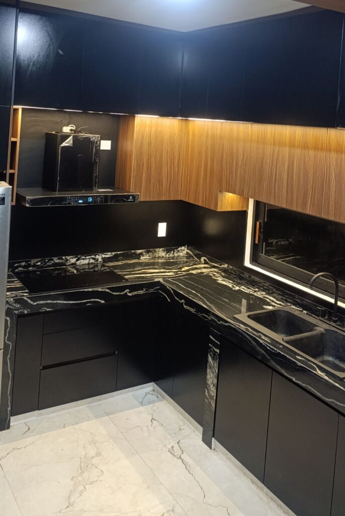 Cocina negra con piedra tecnológica y madera